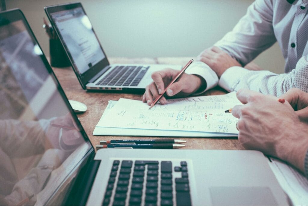 Business professionals collaborating with laptops and documents on desk